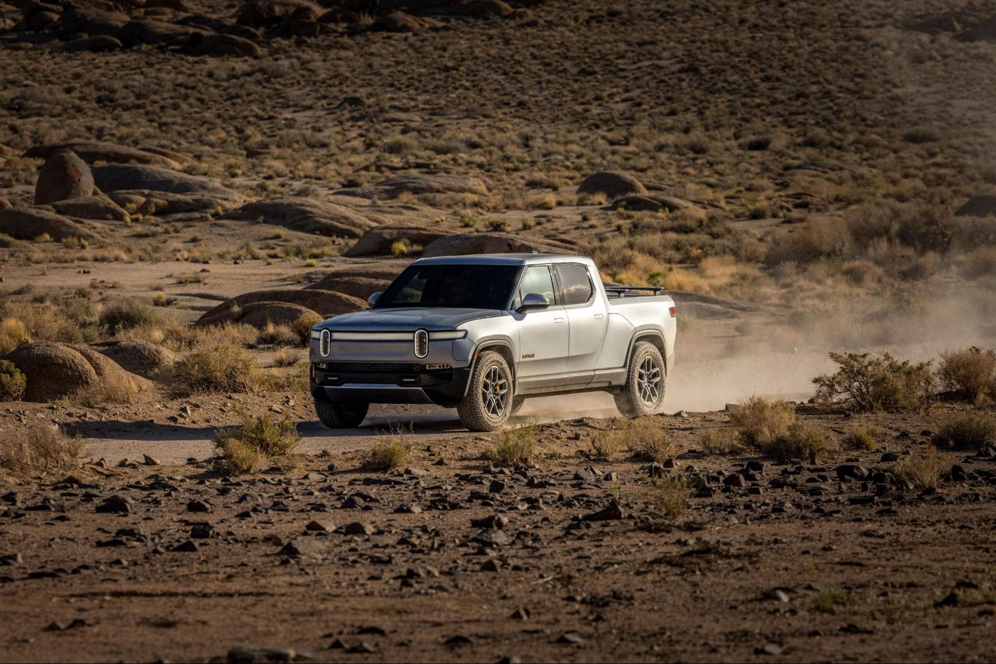 Electric pickup truck driving in a rocky desert